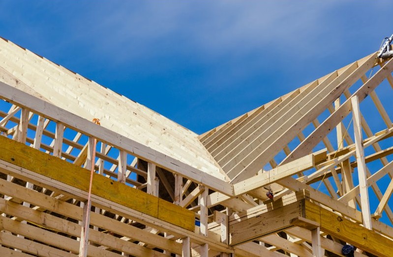 New residential roof framing construction against blue sky